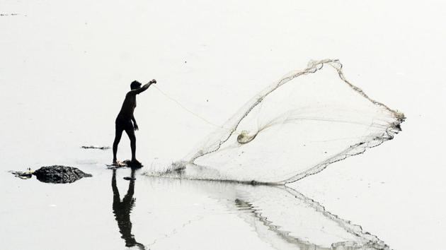 A fisherman and his reflection as he throws a fishing net to the Mula and Mutha river near Aga Khan Bridge, Kalyani Nagar in Pune. (Shankar Narayan/HT PHOTO) A fisherman and his reflection as he throws a fishing net to the Mula and Mutha river near Aga Khan Bridge, Kalyani Nagar in Pune. (Shankar Narayan/HT PHOTO)