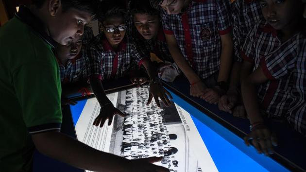 Students look at an interactive photo table with pictures of various political cabinets. Drawcards include a Mercedes car given to former prime minister Rajiv Gandhi by the king of Jordan and a horse-drawn presidential buggy complete with horses. (Chandan Khanna / AFP) 