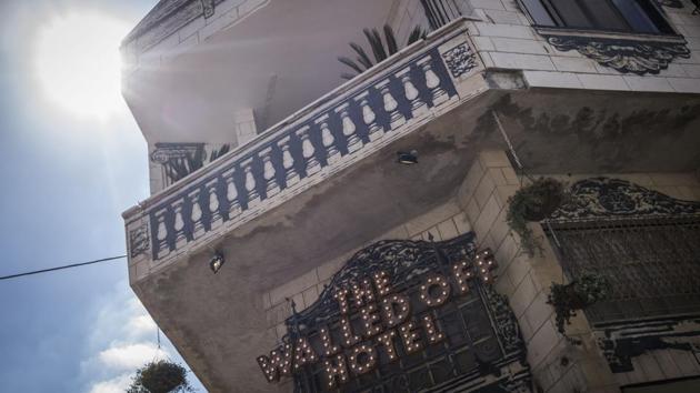 A view of the Walled Off Hotel facade in the West Bank town of Bethlehem. The three-storey hotel, surrounded by the Israeli-Palestine conflict, isn’t necessarily bidding for peace of mind or comfort. The hotel has limited car parking and its 10 rooms get just 25 minutes of direct sunlight a day. (Ilia Yefimovich / Getty Images)