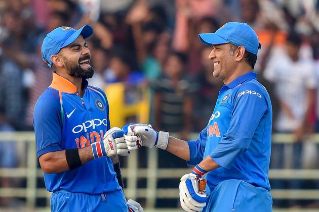 Indian batsmen Virat Kohli and MS Dhoni celebrate after the former completed his complete 10,000 ODI runs during the 2nd ODI cricket match against West Indies in Visakhapatnam. (PTI)