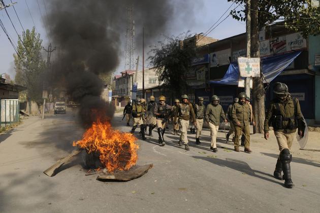 Police personnel on patrol as they pass burning tyres put up as road blockade by protesters near an encounter site in Nowgam area, Srinagar. Two militants were killed on Wednesday in a gunfight with security forces, police said. A combing operation was underway when clashes erupted with youth in the area targeting security forces, pelting stones at them. (Waseem Andrabi / HT Photo) Police personnel on patrol as they pass burning tyres put up as road blockade by protesters near an encounter site in Nowgam area, Srinagar. Two militants were killed on Wednesday in a gunfight with security forces, police said. A combing operation was underway when clashes erupted with youth in the area targeting security forces, pelting stones at them. (Waseem Andrabi / HT Photo)
