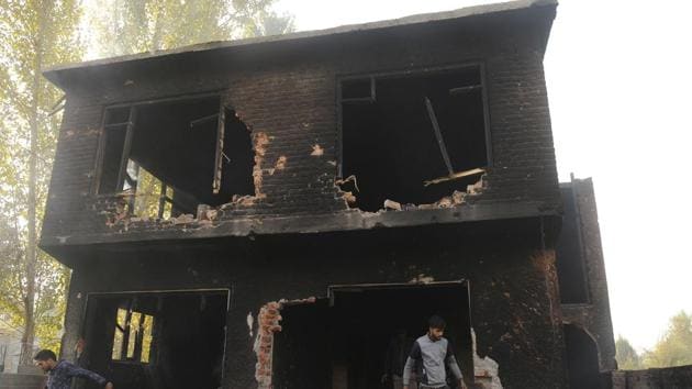 People examine a house that was damaged during a gunfight between militants and security forces in the Nowgam area on the outskirts of Srinagar on October 24.(Waseem Andrabi/HT Photo)