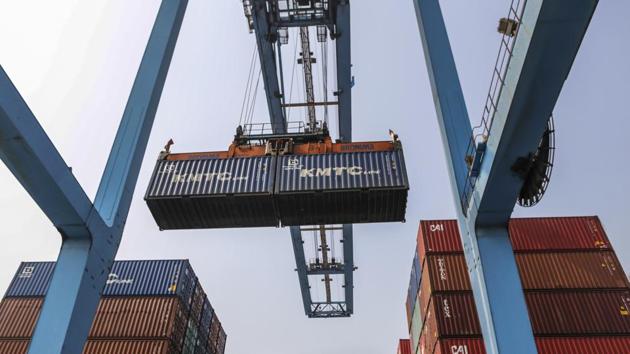 A gantry cranes loads a shipping container onto a truck from a ship docked at the Jawaharlal Nehru Port in Navi Mumbai.(Bloomberg File)
