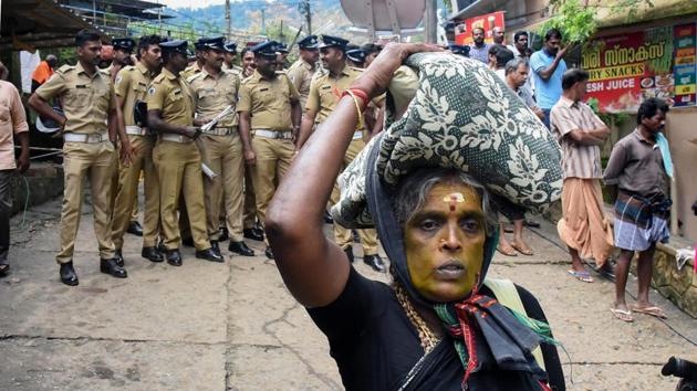 An elderly woman on her way to Sabarimala Temple as police personnel stand on guard (PTI) An elderly woman on her way to Sabarimala Temple as police personnel stand on guard (PTI)