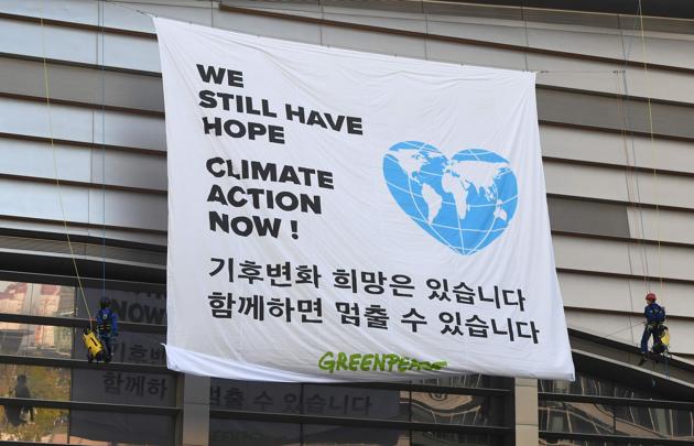 Greenpeace activists display a big banner reading "We still have hope, Climate action now!" during an activity prior to a press conference of the Intergovernmental Panel for Climate Change at Songdo Convensia in Incheon on October 8, 2018(AFP)