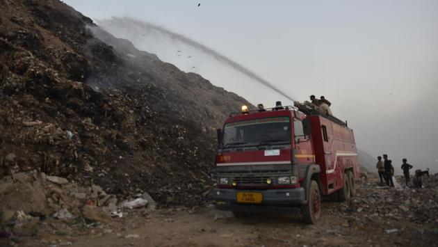 Firefighters douse a fire at Bhalswa landfill which aggravated the city’s pollution, on October 23, 2018. The Supreme Court-appointed body Environment Pollution (Prevention and Control) Authority (EPCA) warned on Thursday that air pollution in the capital is likely to peak from November 1 as toxic fumes from stubble-burning in Punjab and Haryana could gush in because of a change in wind direction. (Sanchit Khanna / HT Photo) 