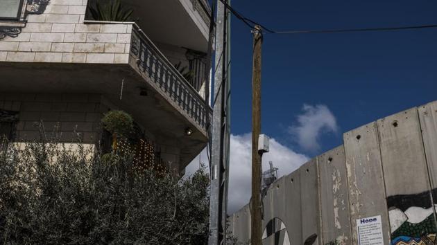Every room of the hotel looks out at the forbidding part wall and part fence that cuts through the West Bank, which Israel says is a bulwark against Palestinian attackers. Palestinians however, see it as a symbol of state oppression. (Ilia Yefimovich / Getty Images)