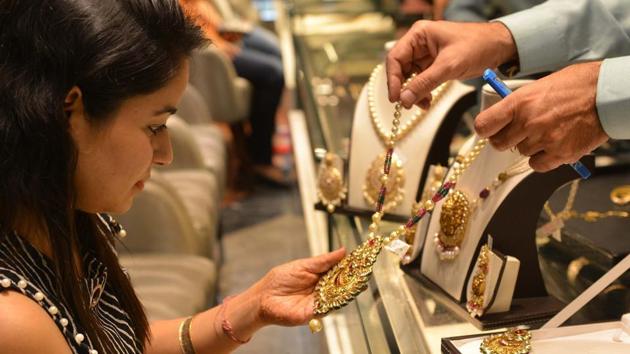 A shopper looks for gold jewellery and ornaments during Dhanteras at a jewellery store in Amritsar on October 17, 2017.(AFP File Photo)