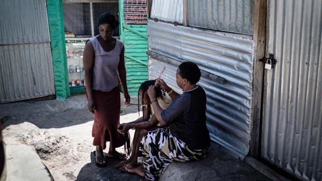 Women braid hair on Migingo island. Kenyan fishermen complained they were being shaken down by the Ugandans, calling on Kenya’s government which deployed security forces in a move that nearly brought the two nations to blows in 2009. (Yashuyoshi Chiba / AFP)