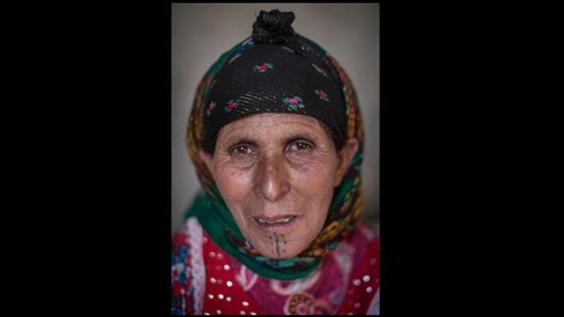 Rabha Abbas, 52 poses for a portrait.The ink work is done for more than adornment. The imagery tells stories of tribes, ties to the land and families. The designs go on chins, cheeks and between the eyes, and extend to forearms as women mark milestones like marriage and motherhood. (Mosa'ab Elshamy / AP)