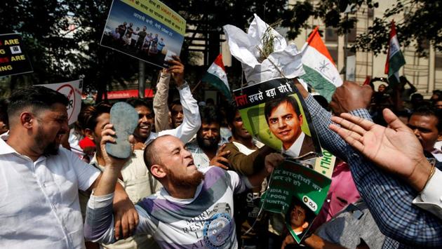 A man hits a poster of Bhavish Aggarwal, CEO and co-founder of Ola, with a slipper during a protest against Ola and Uber outside Uber’s head office in Mumbai, Maharashtra. (Francis Mascarenhas / REUTERS)