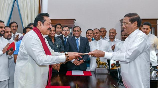 Sri Lanka's former President Mahinda Rajapaksa (Front-L) is sworn in as the new Prime Minister before President Maithripala Sirisena in Colombo, Sri Lanka on October 26.(REUTERS)