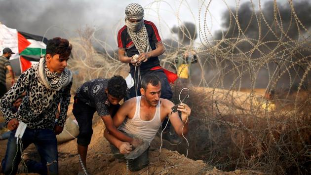 A disabled Palestinian is helped as he uses a sling to hurl stones at Israeli troops during a protest calling for lifting the Israeli blockade on Gaza and demanding the right to return to their homeland, at the Israel-Gaza border fence in Gaza. (Mohammed Salem / REUTERS) A disabled Palestinian is helped as he uses a sling to hurl stones at Israeli troops during a protest calling for lifting the Israeli blockade on Gaza and demanding the right to return to their homeland, at the Israel-Gaza border fence in Gaza. (Mohammed Salem / REUTERS)