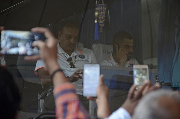 India's cricket team captain Virat Kohli (R) and head coach Ravi Shastri are seen inside the team bus after they landed in Pune for their third one day international match against West Indies in Pune. (HT PHOTO) 