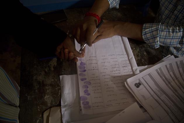 A woman whose name was left out in the National Register of Citizens (NRC) draft gives thumb impression when she submits her form and documents at a NRC center on the outskirts of Gauhati on August 13.(AP File Photo)