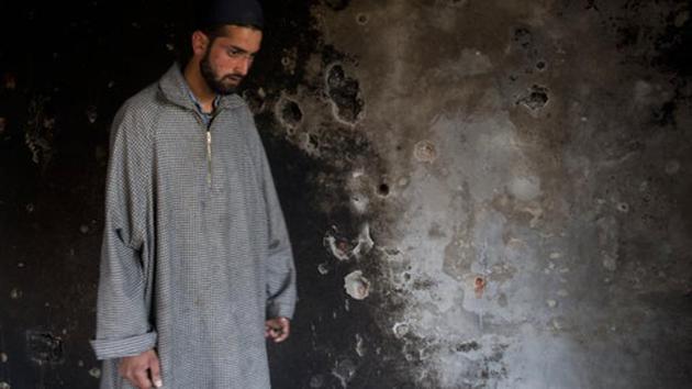 A Kashmiri man inspects a damaged house after a gunbattle between suspected militants and Indian security forces in Srinagar, Jammu and Kashmir. (Dar Yasin / AP)