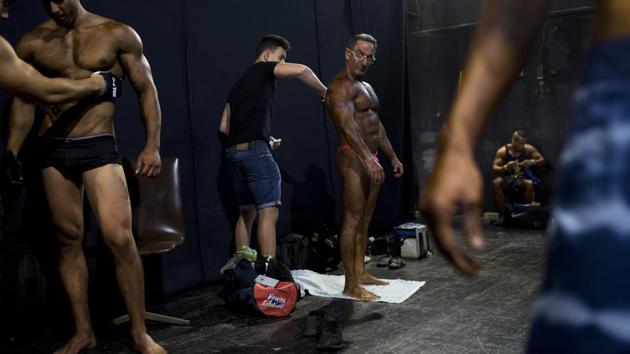 Exhausted from weeks of strict dieting and last-minute exertions, the muscle-bound athletes primped, painted and prepped before taking the stage. (Oded Balilty / AP) Exhausted from weeks of strict dieting and last-minute exertions, the muscle-bound athletes primped, painted and prepped before taking the stage. (Oded Balilty / AP)
