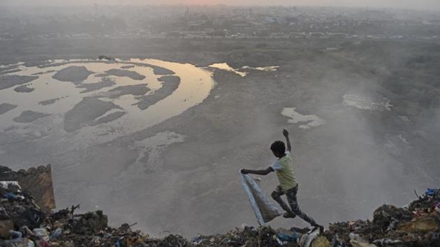 A child runs across a mountain of garbage at Bhalswa landfill in New Delhi. (Sanchit Khanna / HT Photo)
