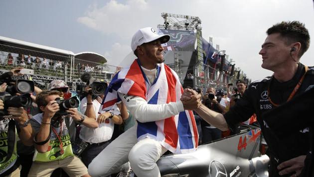 British driver Lewis Hamilton celebrates wining his fourth Formula One championship with a member of his team after the Mexican Formula One Grand Prix auto race at the Hermanos Rodriguez racetrack in Mexico City. (AP) British driver Lewis Hamilton celebrates wining his fourth Formula One championship with a member of his team after the Mexican Formula One Grand Prix auto race at the Hermanos Rodriguez racetrack in Mexico City. (AP)