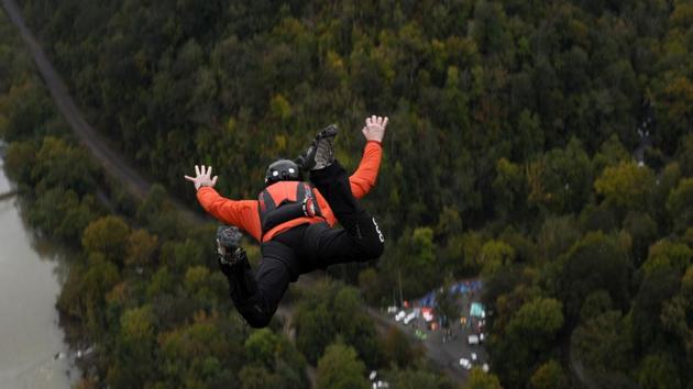 A daredevil with a pilot chute in his backpack plunges toward the New River after diving off the New River Gorge bridge in Fayetteville, West Virginia. 324 BASE jumpers participated in Bridge Day, which began in 1980 and has grown into one of the largest legal BASE jumping events in the world. (Michael Mathes / AFP) A daredevil with a pilot chute in his backpack plunges toward the New River after diving off the New River Gorge bridge in Fayetteville, West Virginia. 324 BASE jumpers participated in Bridge Day, which began in 1980 and has grown into one of the largest legal BASE jumping events in the world. (Michael Mathes / AFP)