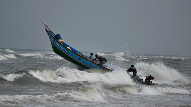 Fishermen steer their boat while out to catch fish near Marina Beach, in Chennai. The North East Monsoon is expected to set in later this month. (PTI)