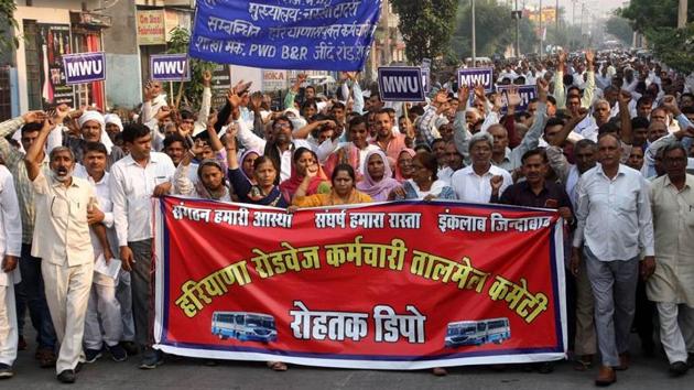 Haryana Roadways workers and members of other unions taking out a protest march in Rohtak on Friday.(HT Photo)