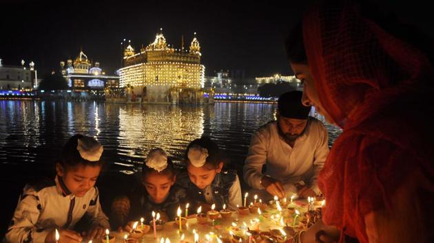 Devotees light candles at the Golden Temple on the occasion of the birth anniversary of fourth Sikh Guru, Guru Ramdass Ji, in Amritsar on Friday. (Sameer Sehgal/HT)