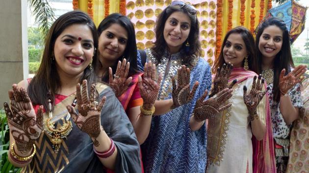 Women show their mehendi (henna) applied hands on the eve of Karva Chauth festival in Amritsar on Friday. Karwa Chauth is a tradition according to which married women or those who are of marriageable age pray for the safety and long life of their husbands, fiances or preferred husbands. (Sameer Sehgal/ht)