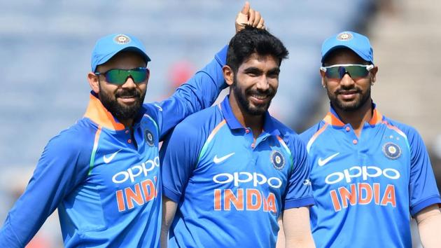 Jasprit Bumrah (C) celebrates with captain Virat Kohli (L) and Shikhar Dhawan after taking the wicket of Kieran Powell.(AFP)