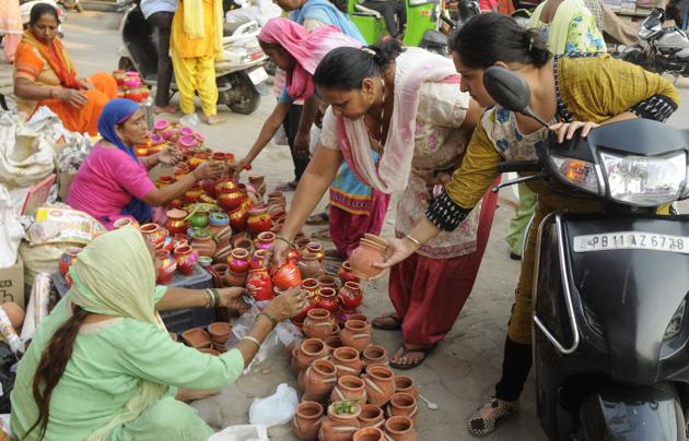 Woman buy new earthen pots some days before the festival, and the pot is decorated with attractive designs and put new sweets and bangles inside them. Then they visit other woman and exchange their karvas. (Bharat bhushan/ht)