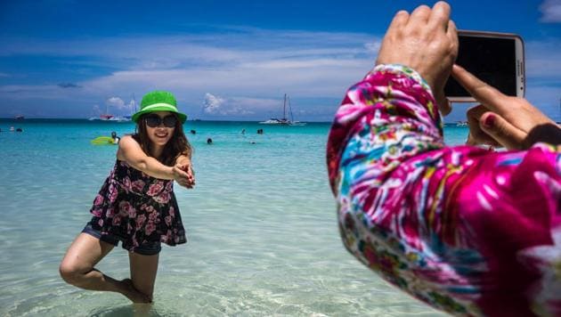 A Chinese tourist poses for a photograph in the sea at White Beach in Boracay, the Philippines.(Bloomberg)