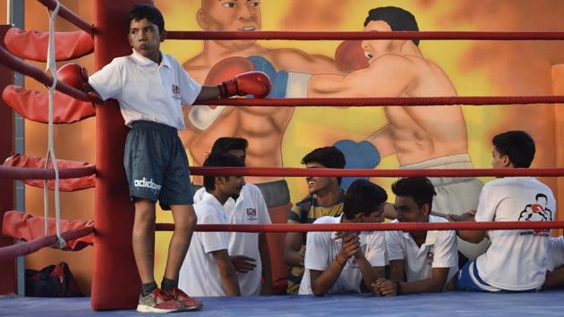 A boy rests ringside at BM Boxing Academy in Najafgarh. This academy, whose founder is Brij Mohan, was inaugurated recently. Until a few years ago, boxing didn’t hold much sway in Najafgarh, but this area where youngsters have traditionally chosen kabaddi, wrestling or cricket, is becoming Delhi’s nursery for boxing. (Vipin Kumar / HT Photo) 
