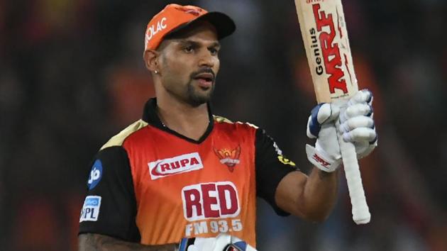 Shikhar Dhawan raises his bat after scoring a half century in the IPL.(AFP)