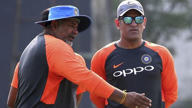 India's Mahendra Singh Dhoni, right, listens to bowling coach Bharat Arun during a practice session.(AP)