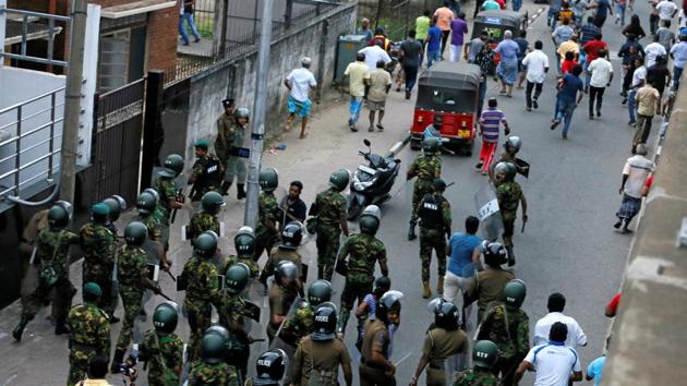 Members of Sri Lanka's Special Task Force and the police chase away supporters of Sri Lanka's newly appointed Prime Minister Mahinda Rajapaksa after an official security guard of sacked minister Arjuna Ranatunga shot and killed one person in front of the Ceylon Petroleum Corporation, in Colombo.(REUTERS)