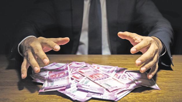 Businessman taking pile of money, Indian Rupee banknotes, on his desk in a dark office - corruption concept (Getty Images/iStockphoto) Businessman taking pile of money, Indian Rupee banknotes, on his desk in a dark office - corruption concept (Getty Images/iStockphoto)