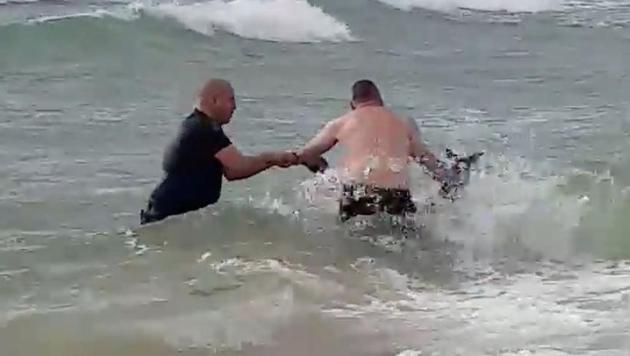 Police officers rescue a kangaroo struggling in the sea at Safety Beach, Victoria, Australia (Mia Grant/REUTERS) Police officers rescue a kangaroo struggling in the sea at Safety Beach, Victoria, Australia (Mia Grant/REUTERS)