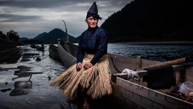 Cormorant master Shuji Sugiyama poses for a portrait in Gifu, Japan. As the night turns pitch black, fires burn alongside a river in Japan’s Gifu with a handful of men preparing for a ritual that dates back over 1,300 years: fishing with cormorants. (Martin Bureau / AFP) Cormorant master Shuji Sugiyama poses for a portrait in Gifu, Japan. As the night turns pitch black, fires burn alongside a river in Japan’s Gifu with a handful of men preparing for a ritual that dates back over 1,300 years: fishing with cormorants. (Martin Bureau / AFP)