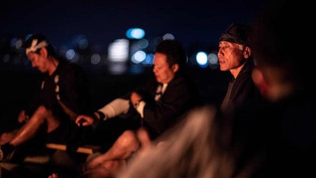 Cormorant masters and their assistants gather around a fire before fishing. Dressed in traditional clothes, they look like they come from another time. They wield their cormorants, tied together with strings, like puppeteers. Their profession, known as “ukai,” was once common in waterside villages and towns throughout Japan and other parts of the world. (Martin Bureau / AFP) Cormorant masters and their assistants gather around a fire before fishing. Dressed in traditional clothes, they look like they come from another time. They wield their cormorants, tied together with strings, like puppeteers. Their profession, known as “ukai,” was once common in waterside villages and towns throughout Japan and other parts of the world. (Martin Bureau / AFP)