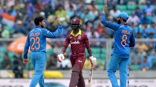 Indian bowler Kuldeep Yadav (L) and Ravindra Jadeje celebrate the dismissal of West Indies batsman Keemo Paul (C) during the fifth one day international (ODI) cricket match between India and West Indies at the Greenfield International Stadium in Thiruvananthapuram.(AFP)