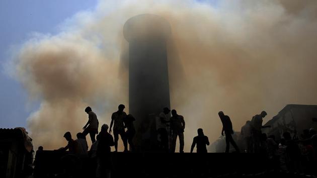People are silhouetted against the smoke as firefighters try to douse a fire at a slum in Mumbai on October 30, 2018. (Rafiq Maqbool / AP) People are silhouetted against the smoke as firefighters try to douse a fire at a slum in Mumbai on October 30, 2018. (Rafiq Maqbool / AP)