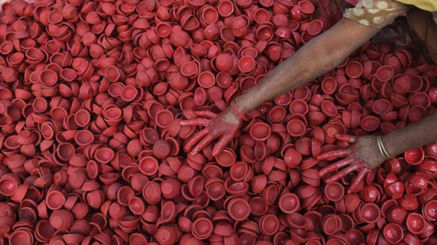 A woman colours earthen lamps ahead of Diwali festival in Jammu, Jammu and Kashmir on October 30, 2018. (Channi Anand / AP) A woman colours earthen lamps ahead of Diwali festival in Jammu, Jammu and Kashmir on October 30, 2018. (Channi Anand / AP)