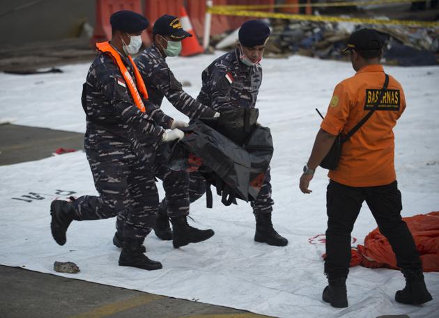 Indonesian military personnel carry the remains of a victim of the ill-fated Lion Air flight JT 610 at Jakarta port during search operations in the waters off Karawang.(AFP)