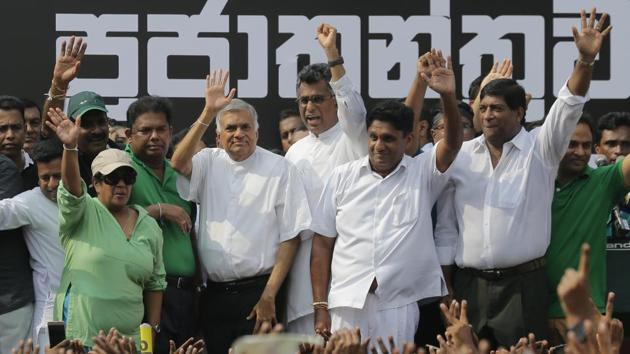 Sri Lanka's sacked prime minister Ranil Wickremesinghe, third from left in white shirt and black trousers, waves to his supporters along with law makers supporting him during a protest rally outside the prime minister’s official residence in Colombo. (AP) Sri Lanka's sacked prime minister Ranil Wickremesinghe, third from left in white shirt and black trousers, waves to his supporters along with law makers supporting him during a protest rally outside the prime minister’s official residence in Colombo. (AP)