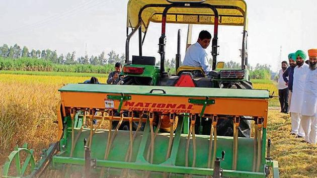 A farmer sows wheat using a mechanised seeder in a village in Karnal, Haryana.(HT Photo)