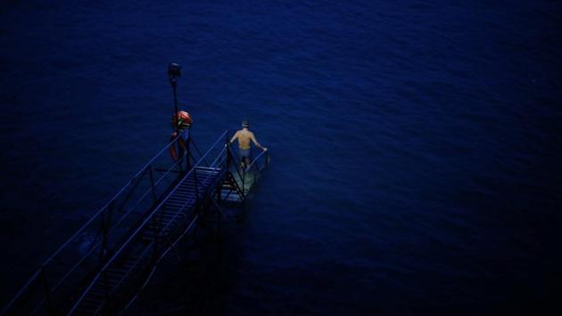 A swimmer enters the sea before dawn at the Sai Wan Swimming Shed in Hong Kong. For nearly 30 years, Sandy Lam has been rising early each day for a dip in the sometimes choppy waters off the western edge of Hong Kong island, next to one of the world’s busiest ports. (REUTERS / Hannah McKay) A swimmer enters the sea before dawn at the Sai Wan Swimming Shed in Hong Kong. For nearly 30 years, Sandy Lam has been rising early each day for a dip in the sometimes choppy waters off the western edge of Hong Kong island, next to one of the world’s busiest ports. (REUTERS / Hannah McKay)