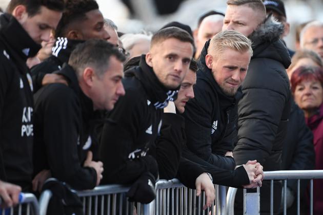 Leicester City's Danish goalkeeper Kasper Schmeichel (R) stands beside Leicester City's English striker Jamie Vardy as they look at the floral tributes left to the victims of the helicopter crash which killed Leicester City's Thai chairman Vichai Srivaddhanaprabha,(AFP)