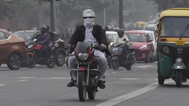 A motorcyclist covers his face to protect himself from the air pollution near Pragati Maidan in New Delhi (Arvind Yadav/HT PHOTO) A motorcyclist covers his face to protect himself from the air pollution near Pragati Maidan in New Delhi (Arvind Yadav/HT PHOTO)