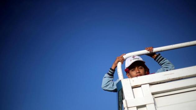 A migrant, travelling with a caravan of thousands from Central America en route to the United States, hitchhikes on a truck along the highway to Santiago Niltepec from San Pedro Tapanatepec, Mexico. (Hannah McKay / REUTERS)