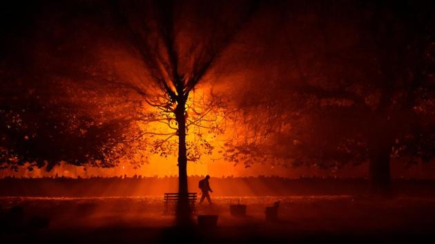 A man uses a torch to walk through a park during cold fog at night in Athboy, Ireland. (Clodagh Kilcoyne / REUTERS)